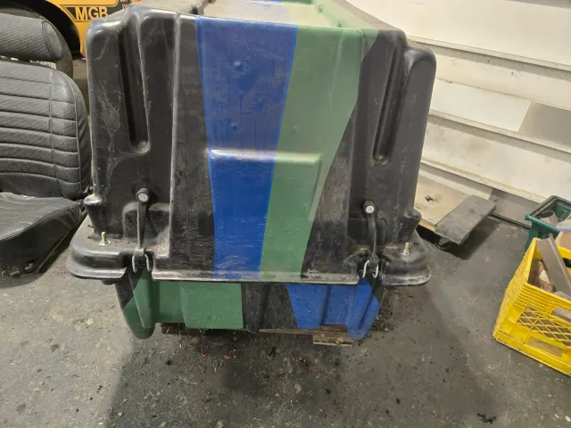 Plastic grit bin stored in workshop corner