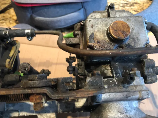 Grimy carburettor and linkage before cleaning