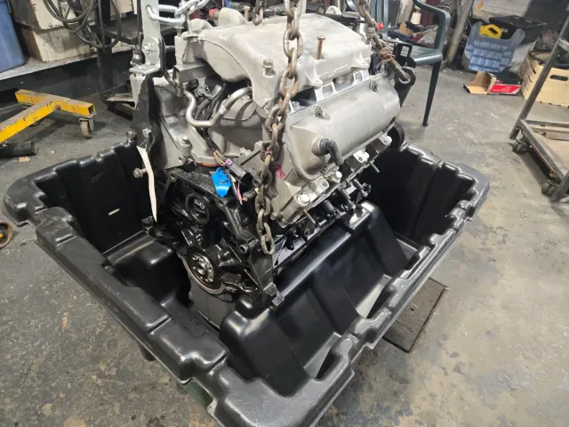 Modern V6 engine lifted in plastic crate