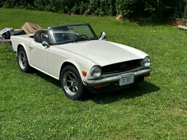 White TR6 roadster parked on grass