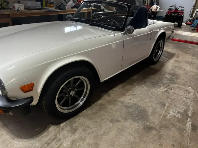 White TR6 roadster in garage, hood down