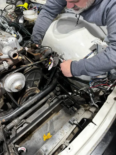 Mechanic working in engine bay with wing removed
