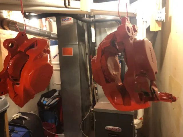 Freshly painted red brake calipers hanging to dry