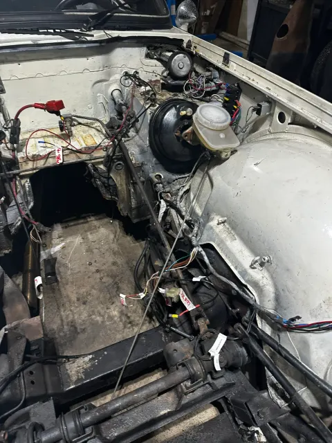 Stripped engine bay with brake servo and wiring