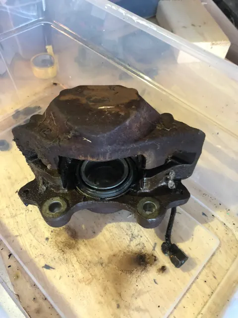 Corroded front brake caliper removed from car