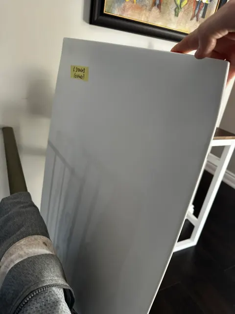 Grey painted test panel held up indoors