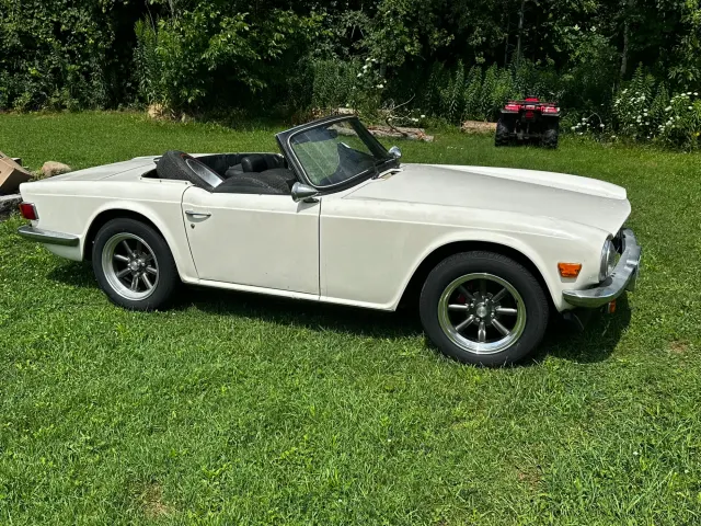 White TR6 roadster side view on grass