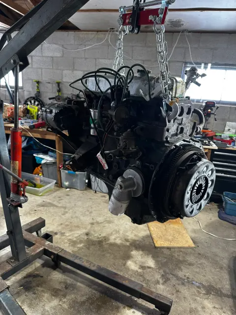 Engine lifted on hoist in garage