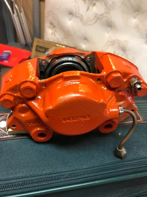 Rebuilt front brake caliper in orange paint