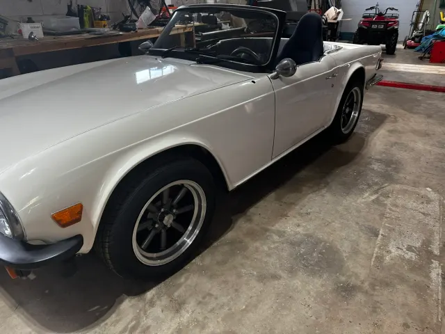 White TR6 with black alloy wheels in garage