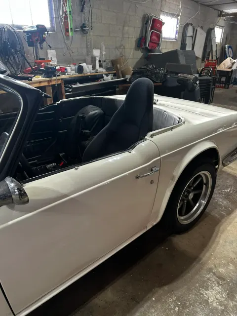 White TR6 rear quarter in workshop