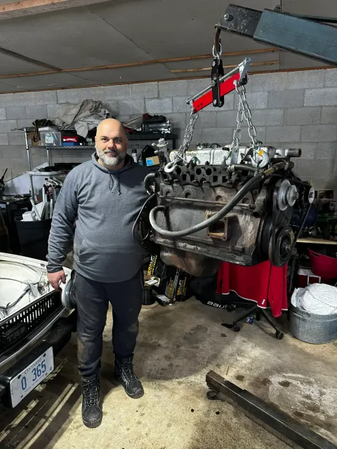 Engine block lifted on hoist in garage