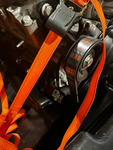 Engine supported by orange lifting strap