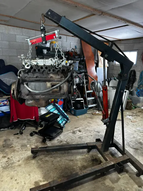 Engine suspended from hoist with leveller bar