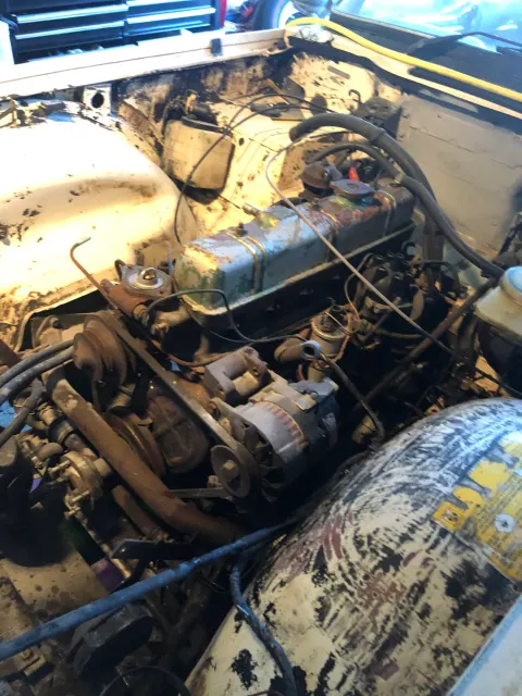 Grimy inline-six engine bay before teardown